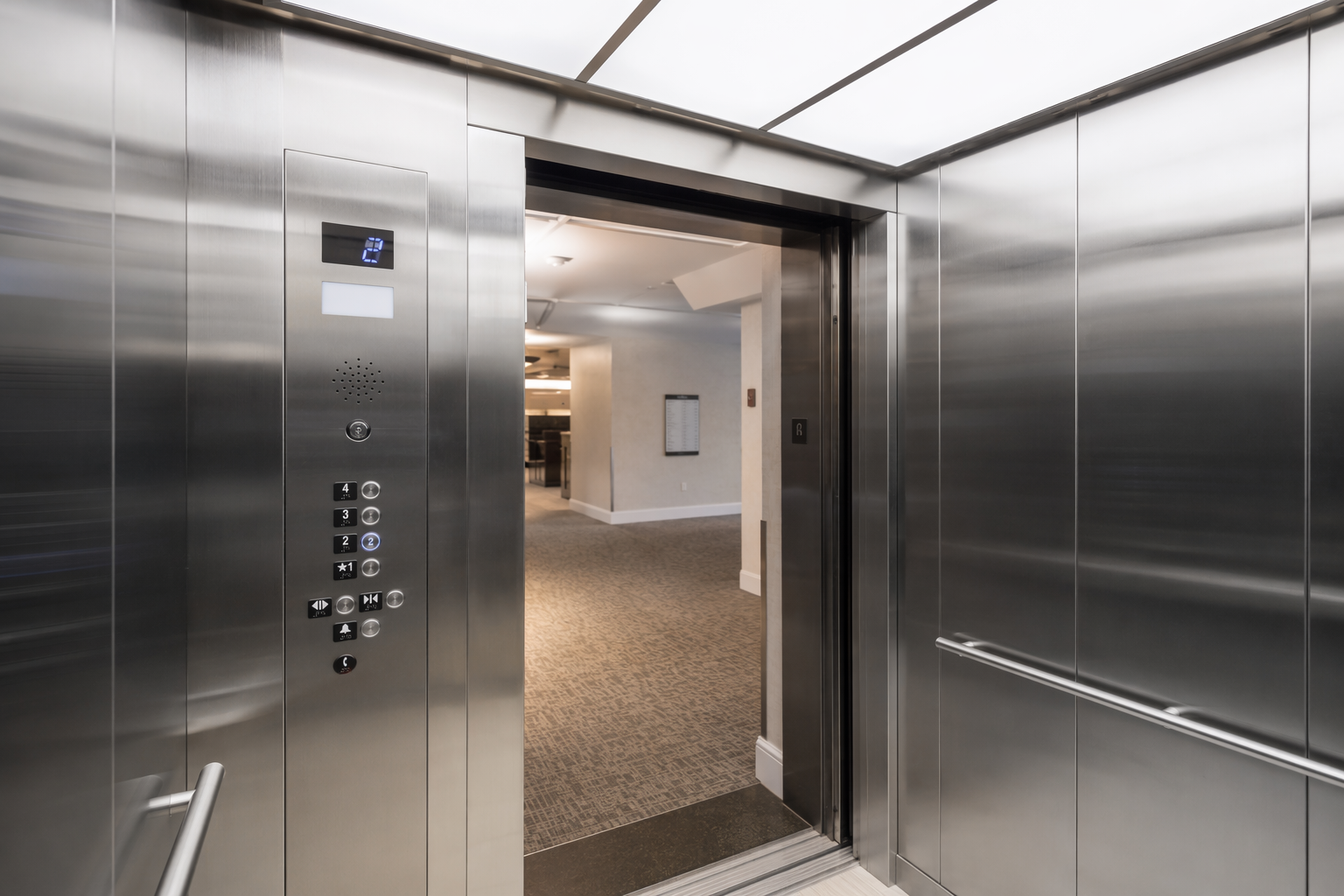 Modernized elevator cab interior with ADA-compliant controls and LED lighting after elevator modernization service in a Sarasota, FL office building.