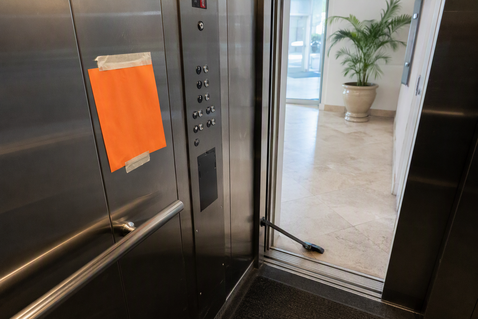 Commercial elevator cab in Pompano Beach Florida posted out of service with orange placard while awaiting DBPR certificate of operation renewal inspection after expiration